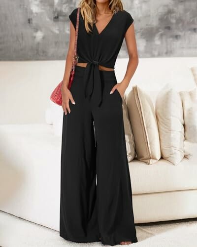 Woman wearing a black jumpsuit with a tie-front design.