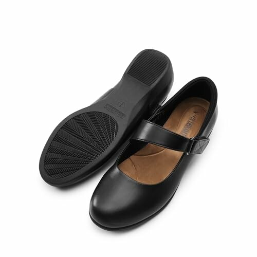 Pair of black Mary Jane shoes with strap.