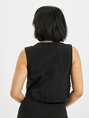 Person wearing a black sleeveless top, seen from the back.