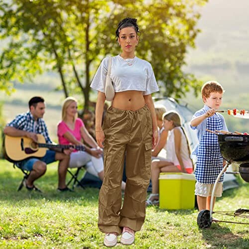 People enjoying a barbecue outdoors with a woman in the foreground.