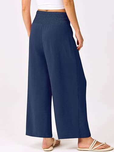 Person wearing navy wide-leg pants and sandals.