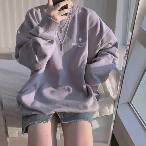 Person wearing an oversized sweater taking a mirror selfie.