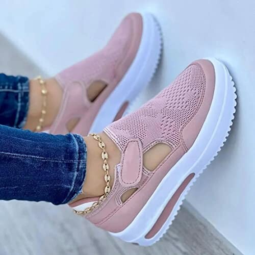 Pink slip-on sneakers with white soles worn with jeans and anklets