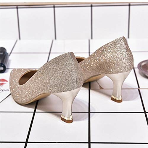 Pair of sparkly gold mid-heel shoes on a tiled surface.