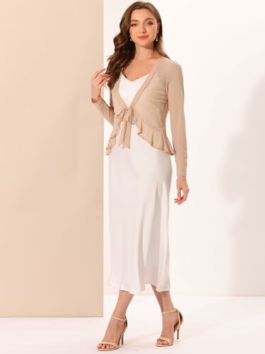 Woman wearing a beige cardigan over a white dress