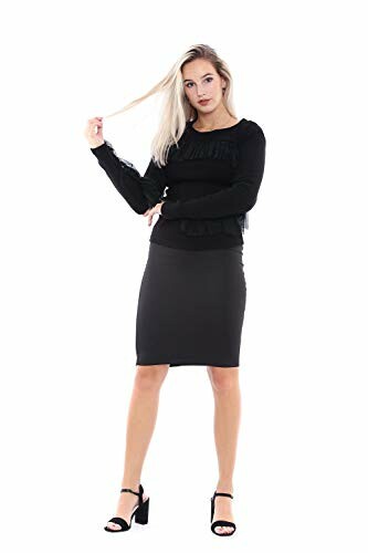 Woman in black dress with long sleeves and black heels.