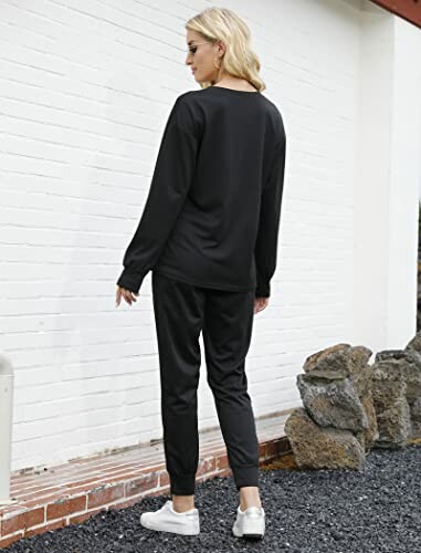 Woman in a casual black outfit standing outside