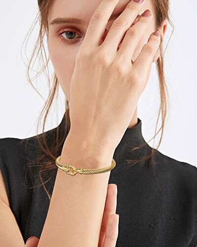 Woman wearing a gold bracelet on her wrist.
