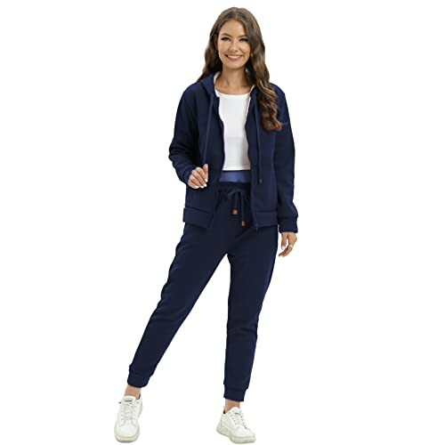 Woman wearing a navy tracksuit and white sneakers.