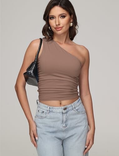 Woman wearing a one-shoulder top and jeans.