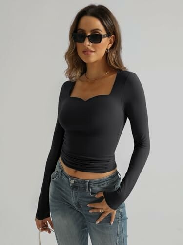 Woman in black top and jeans wearing sunglasses