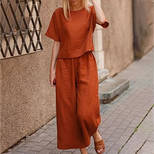 Woman in brown two-piece outfit walking on a sidewalk.