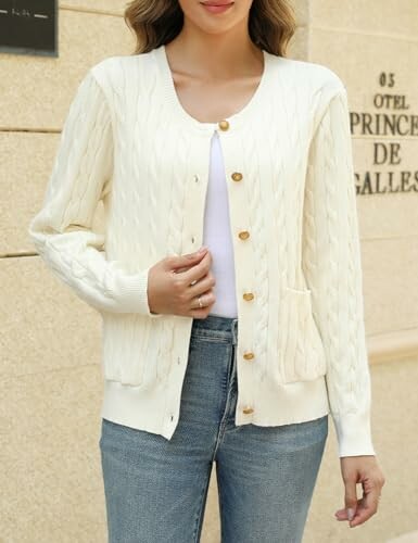 Woman in cream cardigan with buttons and jeans.