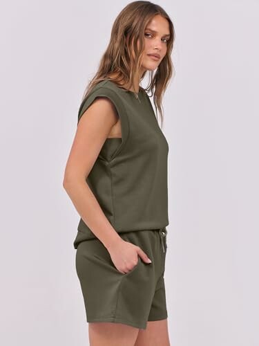 Woman in green sleeveless top and shorts.