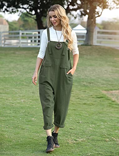 Woman walking outdoors in green overalls.