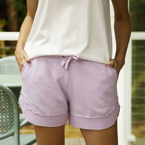 Woman in lavender shorts and white top.