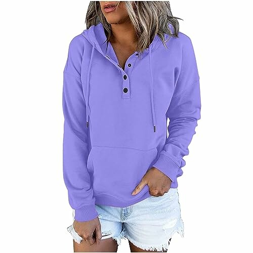 Woman in a purple hoodie and denim shorts